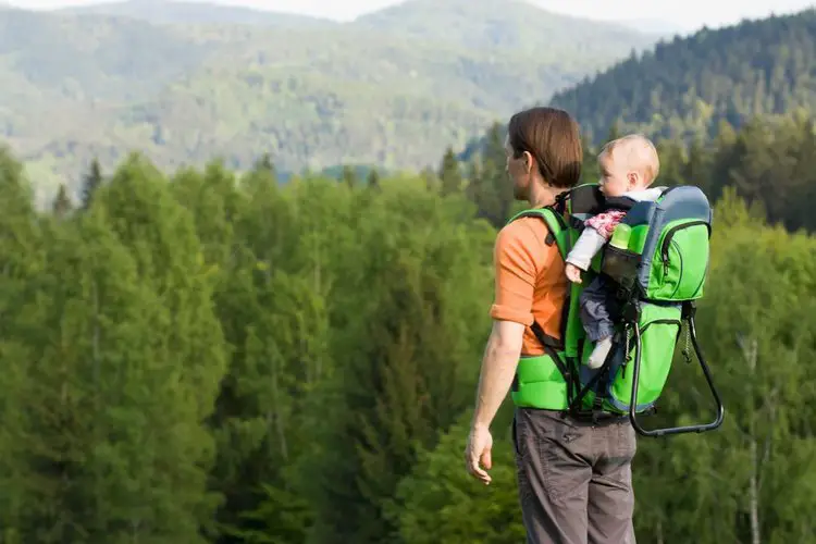 man with baby in hiking backpack carrier