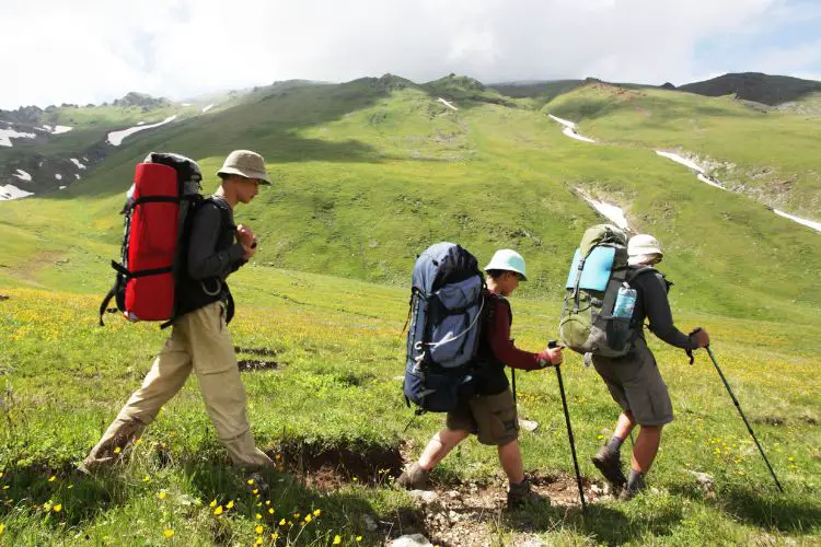 a group with heavy big hiking backpacks is hiking