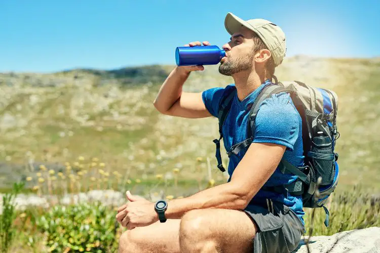 a man is drinking after a hike