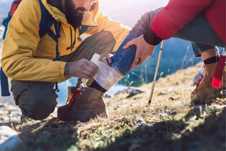 a man tends the wound of a woman after hiking