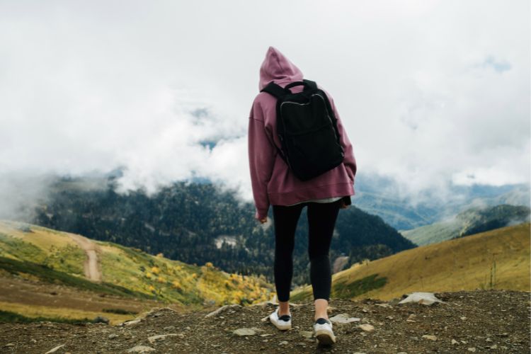 a woman wears yoga pants for a hiking trip in mountain