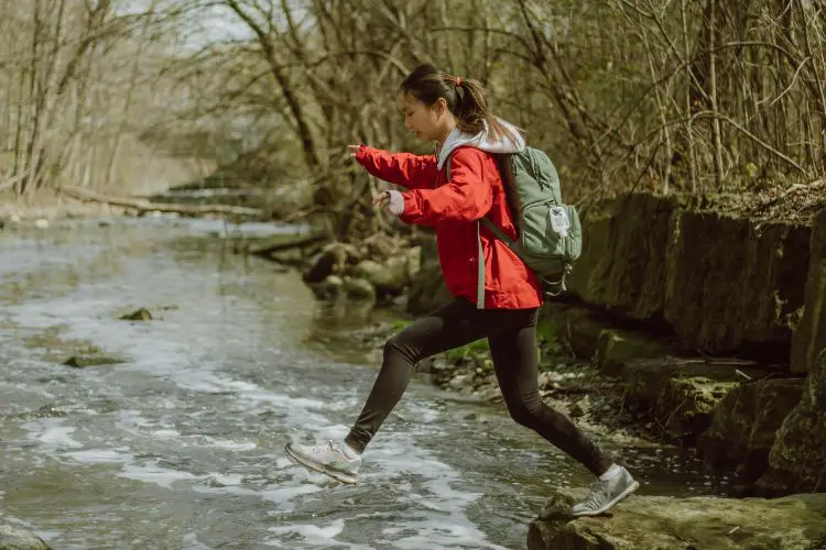 girl is jumping through the stream