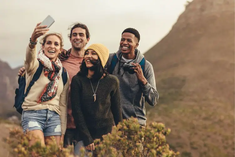 group of friends are taking selfie while hiking