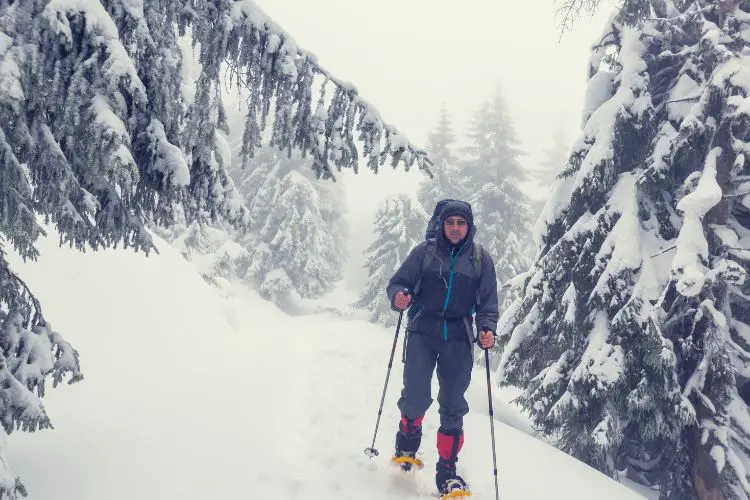 man is hiking in winter snow