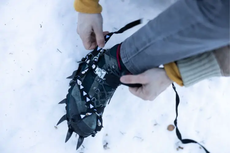man is wearing crampon for his hiking boot