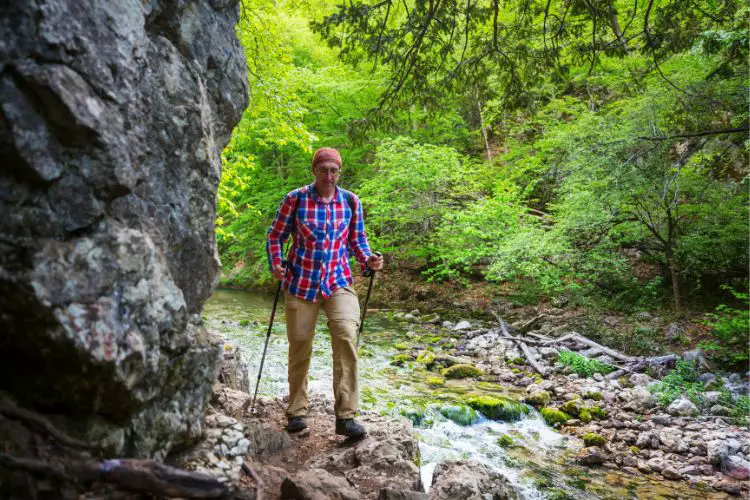 old man is hiking with hiking poles