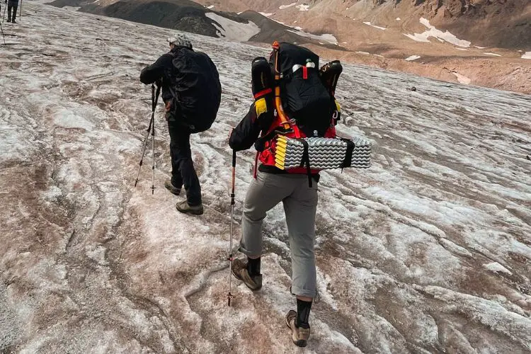 two hikers are going downhill in winter