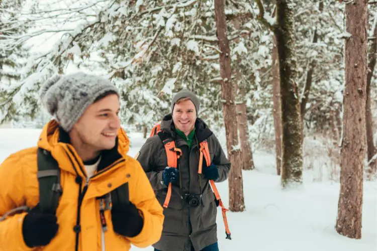 two men wear warm clothes for winter hike