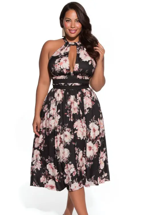 A plus-size women wears black floral wedding guest dresses