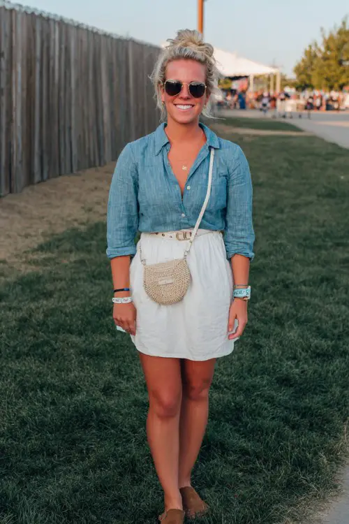 A midsize woman wears a relaxed denim shirt tucked into a white mini skirt with a casual belt bag
