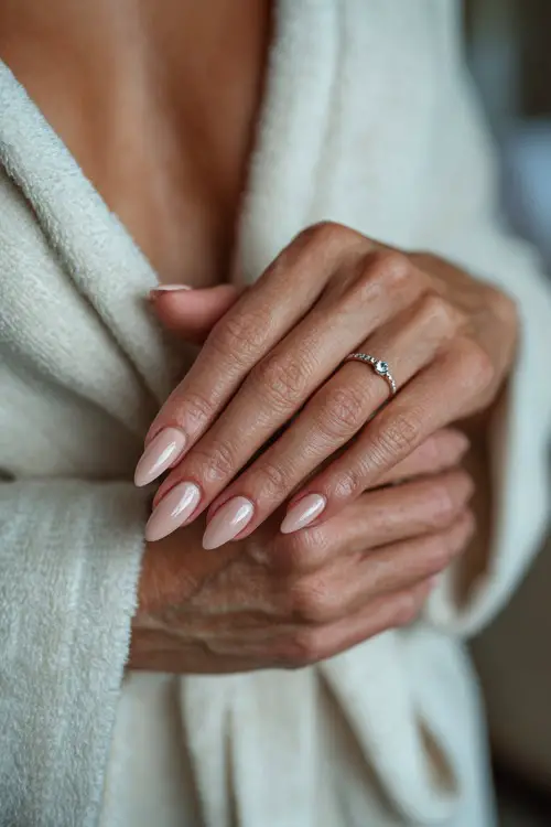 Bride’s hand tied with soft chiffon, almond nails in muted blush pink with shimmer fade and single crystal bead at the base of each nail 