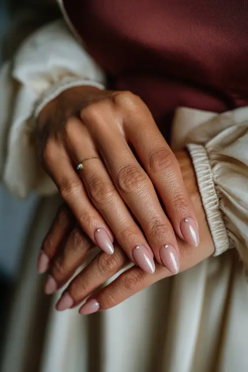 Bride’s hand tied with soft chiffon, almond nails in muted blush pink with shimmer fade and single crystal bead at the base of each nail 