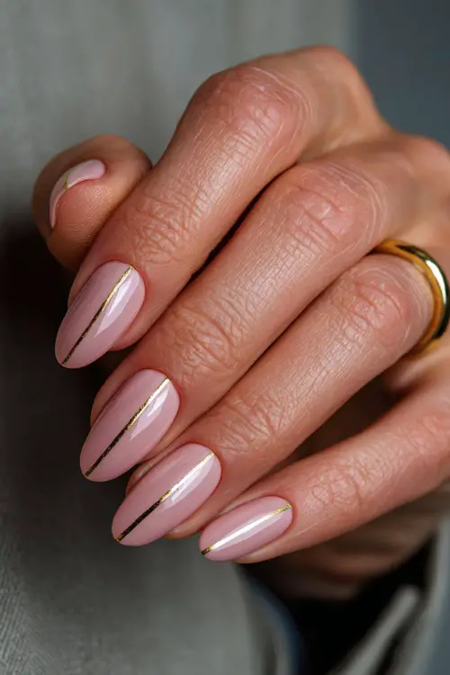 Elegant bridal hand adjusting hairpin, almond nails painted in pastel peach with matte finish and gold stripe detail across each tip 
