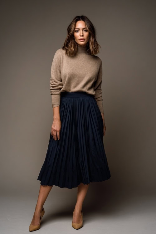 Full-body portrait of a woman in a navy pleated midi skirt with a tucked-in taupe sweater, tan heels, and minimal accessories, soft studio light 