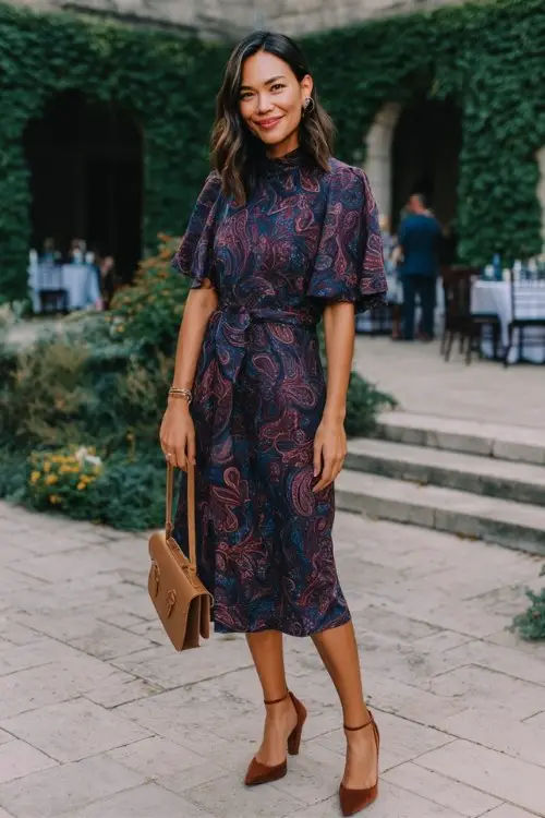 a woman wears a purple fall wedding guest dress for a November wedding