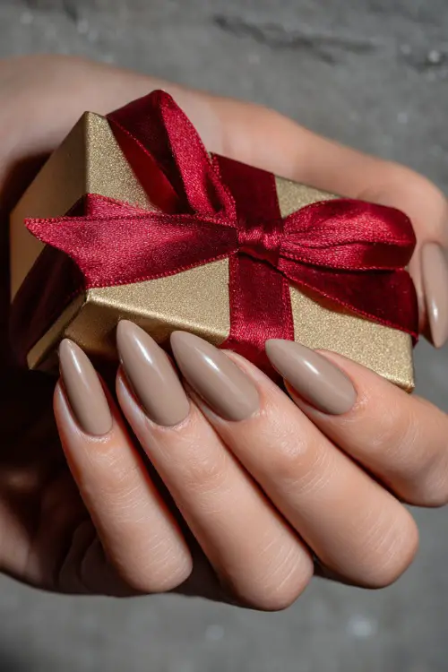 Almond-shaped warm beige nails with a smooth matte finish, guest holding a wedding favor box