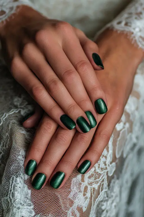 Elegant emerald green nails with metallic sheen, bridesmaid’s hands resting on a lace shawl 