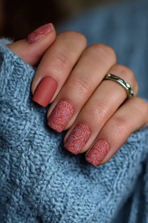 Matte terracotta nails with delicate floral line art, bridesmaid holding a wedding program booklet