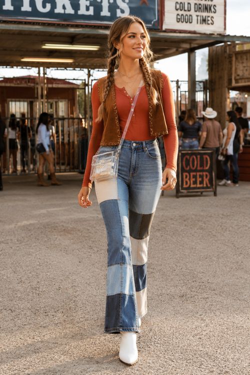 a woman in a fall country concert outfit with jeans, a rust top and white boots