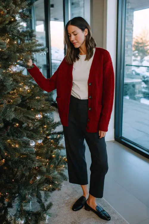 A woman in a red cardigan layered over a simple white tee with black trousers and loafers