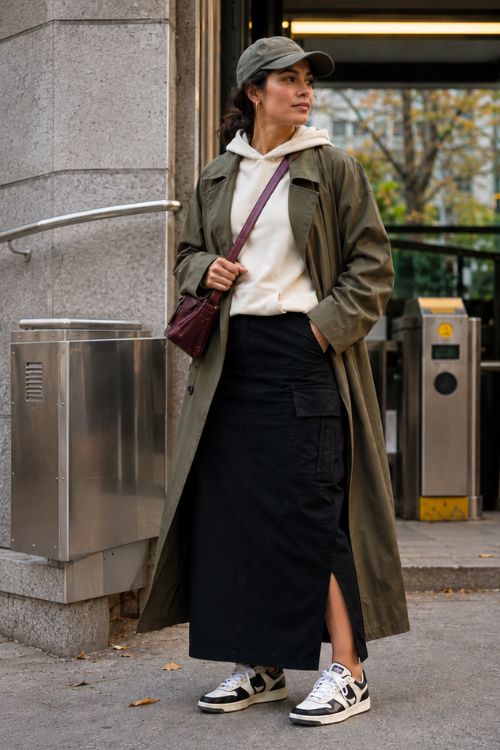 a woman in black cargo maxi skirt with a hoodie and olive trench coat