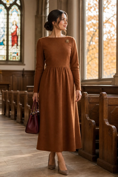 Brown Midi Dress with Brooch A woman wears a long-sleeve brown midi dress with a brooch, burgundy handbag, and taupe pumps.