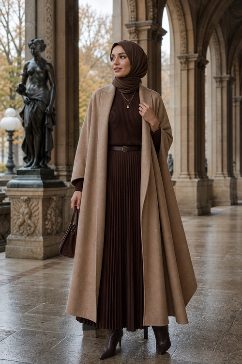 Elegant Brown and Taupe Modest Outfit A woman wears a brown hijab, ribbed pleated maxi dress, taupe long coat, ankle boots, belt, necklace, and handbag.