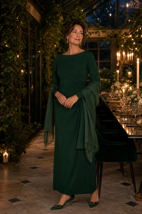 Woman wearing a long emerald green dress with a draped shawl and matching pointed-toe heels at an elegant candlelit dinner setting.