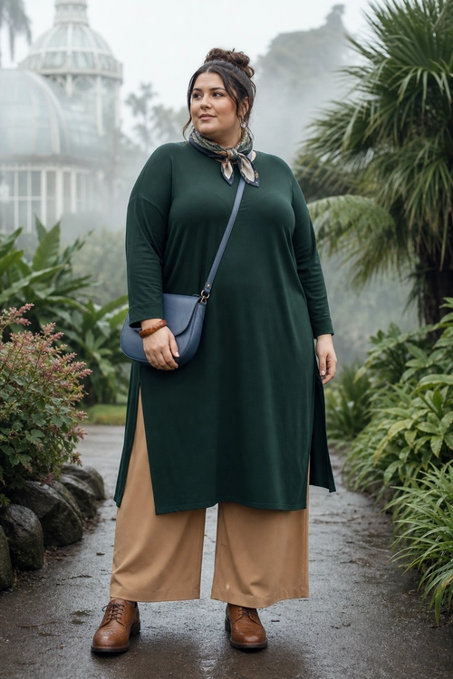Forest Green Tunic with Wide-Leg Trousers A forest green long tunic worn over tan wide-leg trousers with brown lace-up boots, a blue-gray crossbody bag, and a patterned neck scarf.