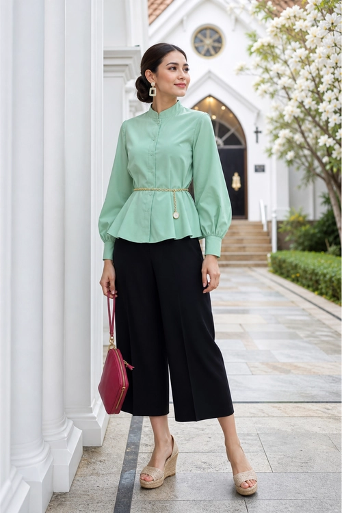 Mint Green Blouse with Black Culottes A woman wears a mint green long-sleeve blouse with a belted waist, black wide-leg culottes, beige wedge sandals, and a burgundy handbag.