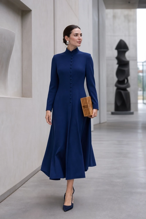 Navy Button-Front Dress Woman wearing a navy long-sleeve button-front dress with pointed heels, earrings, and a textured brown clutch.