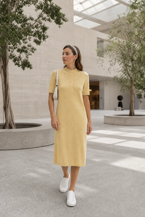 Yellow Knit Midi Dress Outfit Woman wearing a yellow short-sleeve knit midi dress with white sneakers, a small white shoulder bag, and a headband.