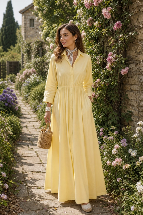 Yellow Maxi Dress with Woven Basket Bag Woman wearing a pale yellow long-sleeve maxi dress with a printed neck scarf and carrying a woven basket bag.