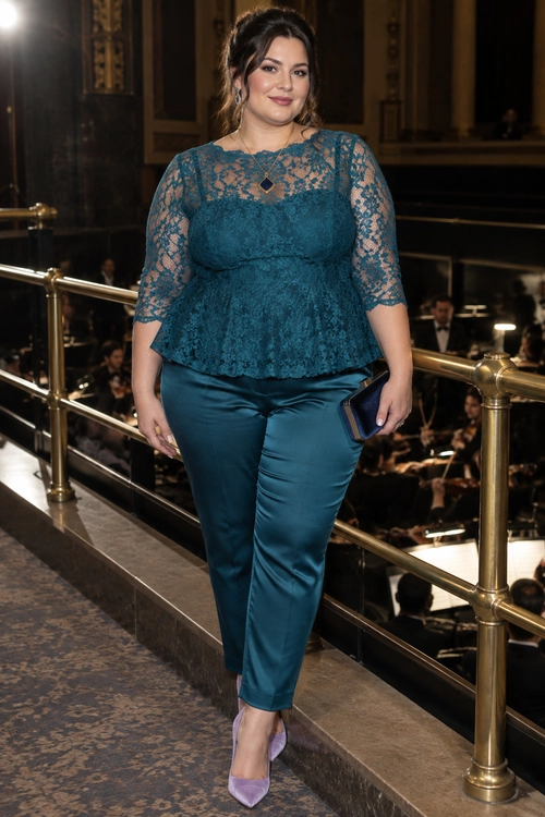 A teal lace peplum top and matching trousers styled with lavender pointed-toe pumps and a dark blue clutch.